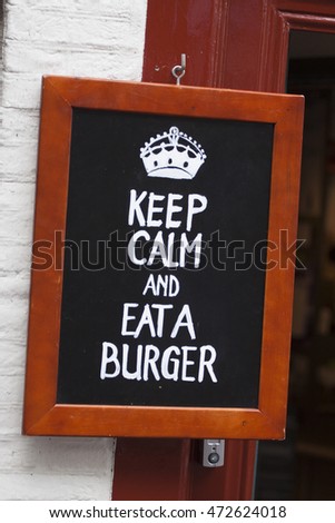 Advertising text on a blackboard : Keep calm eat a burger