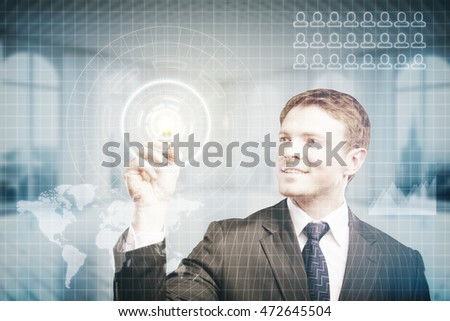 Happy young businessman pressing virtual buttons on digital interface with abstract map. Blurry interior background