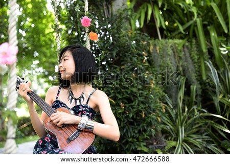 Thai woman with Ukulele in garden