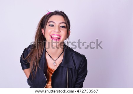 Portrait of fashionable young woman wearing stylish urban clothes. Fashion studio portrait over grey background.