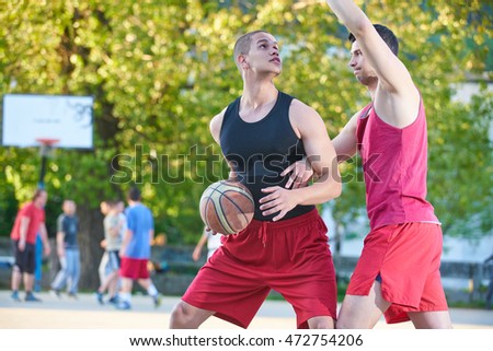 group of happy teenage friends playing basketball                           