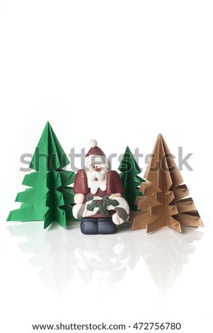Funny Santa Claus figure with origami trees isolated on white background.