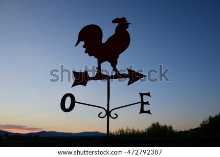 rooster weather vane, silhouette against the sky, dawn