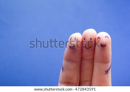 Three smiling fingers that are very happy to be friends. Friendship teamwork concept on blue background with copy space for ad text.