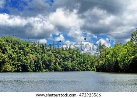 Cable cars on the skyrail passing over the Barron River in Kuranda, Australia Royalty-Free Stock Photo #472925566