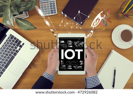 IOT business man hand working and internet of things (IoT) word diagram as concept