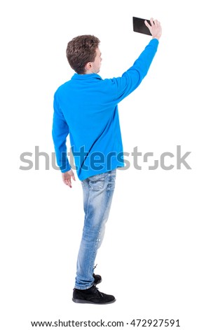 back view of standing business man photographing a phone or tablet. Rear view people collection.  backside view of person.  Isolated over white background. Curly boy in blue sweater makes selfie