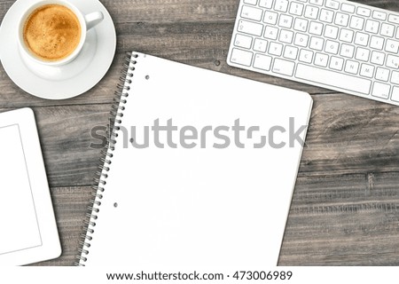 Digital tablet pc, keyboard and cup of coffee on wooden table. Retro style toned picture