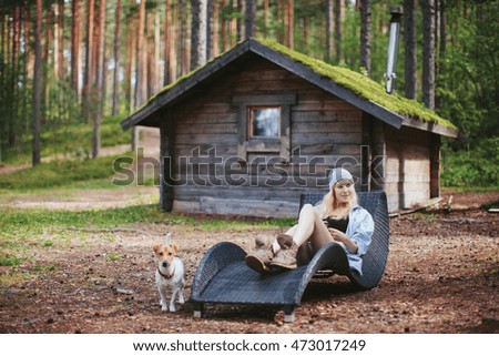 Girl with a book resting on a lounger in a forest glade