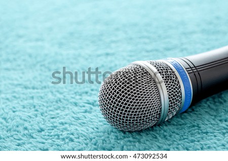 Close-up of microphone on green carpet background. Toned image.