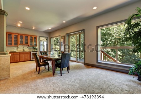 Open floor plan dining room with view of kitchen cabinetry. Beige carpet floor and opened glass sliding doors to balcony. Northwest, USA