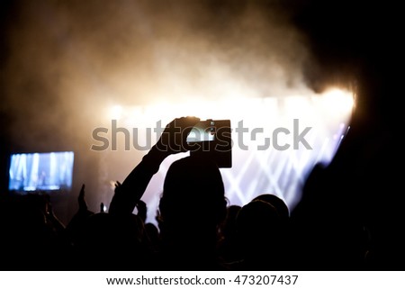 Close up of photographing with smartphone during a concert