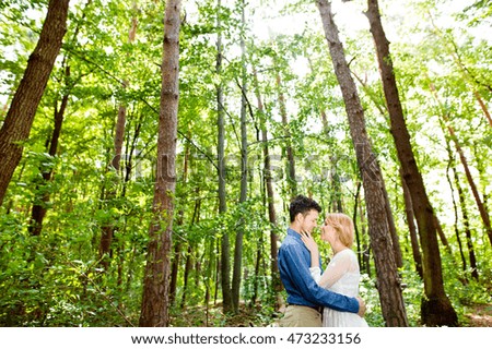 Beautiful wedding couple outside in green forest.