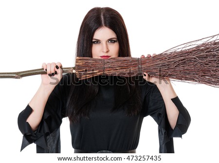 Upset young witch with broom over white background close-up