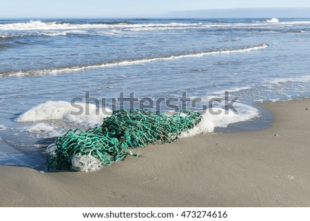 Green fishing net on the North Sea Beach of the island of Terschelling in the North of the Netherlands
