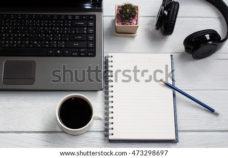 Blank notebook with pencil and cup coffee,laptop,mobile-phone on table background copy space / selective focus