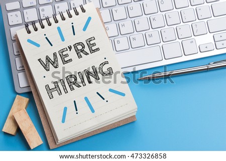 Word text We're hiring on white paper on office table / business concept