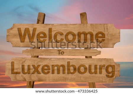 Welcome to Luxembourg sign on wood background with blending national flag