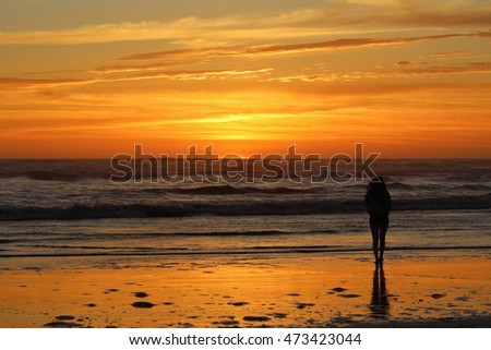 Woman's silhouette on a beautiful beach at sunset. 