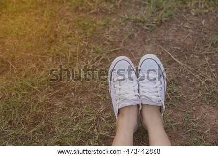 Women Sports Shoes and Meadows. Sit back and relax with evening light. Mock orange-made.