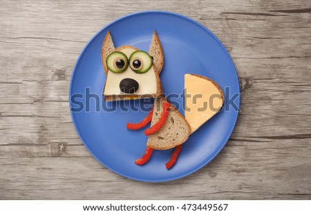 Squirrel made of bread and vegetables on plate and desk