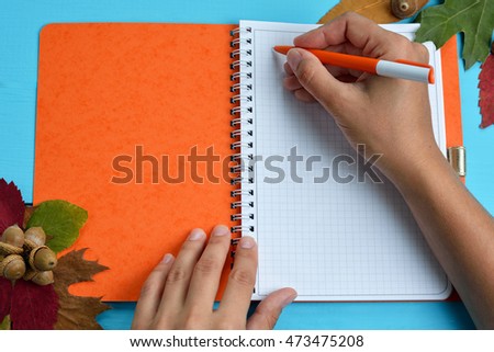 hand is writing on blank notebook