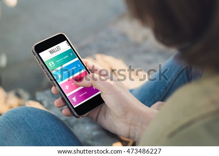woman surfing a wallet app with her mobile. All screen graphics are made up.