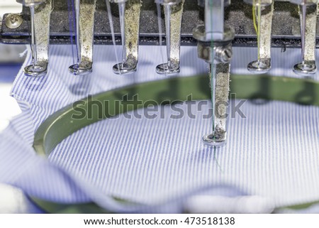 close-up embroidery machine (soft focus) background.