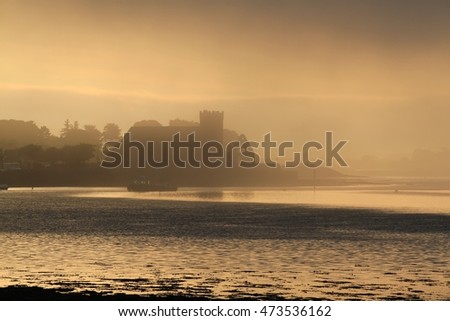 Mist gathering around a church in a bay at sunrise in ireland