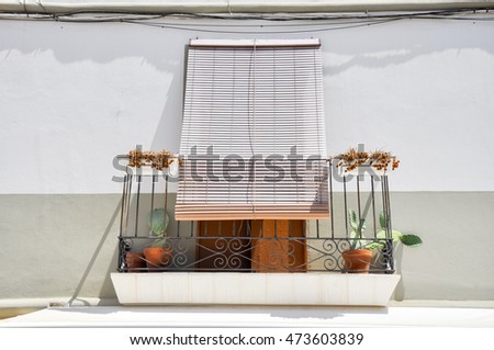 balcony with plants and shutters and awning in front view