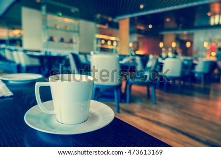 White Coffee cup on the table in lounge bar background.