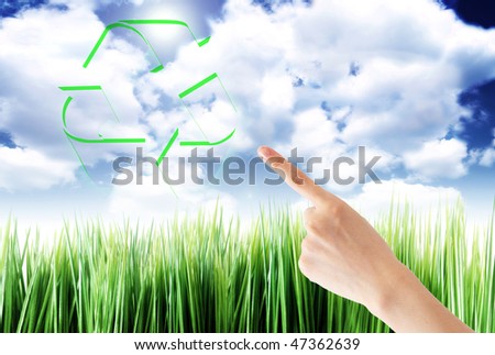 hand pointing a recycle symbol on a field background