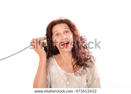 portrait of a cute middle aged woman hearing through tin can phones isolated over a white background