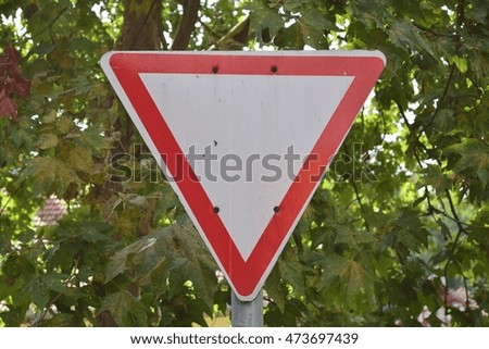 Yield road sign with tree in the background