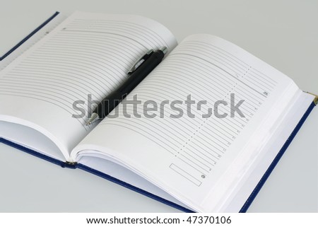  Empty open diary and black pen.  Isolated on white background.