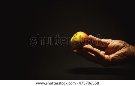 Conceptual composition about healthy food. Man's hand holding an apple. 