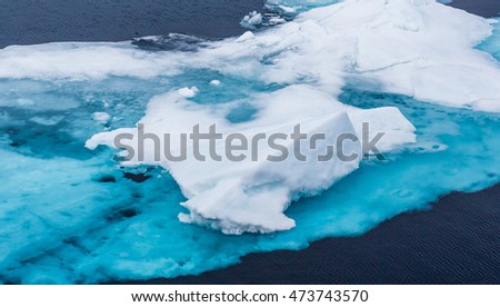 Turquoise blue glacier ice floats in the Arctic