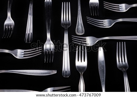 Composition of forks on a black background