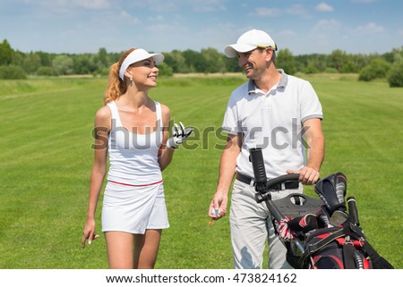 So much fun golfing. Portrait of a young cheerful couple taking a break off playing golf laughing together on a golf course
