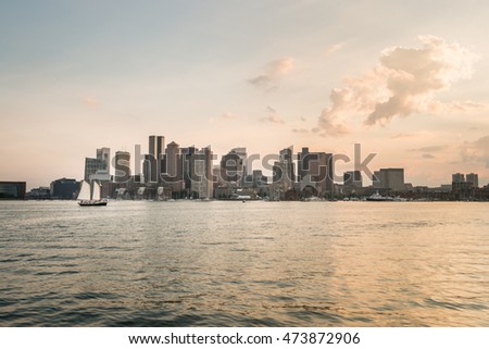 Skyline of Boston, Boston Harbor  and sailing yacht  in a warm sunset light, seen from the East Boston 