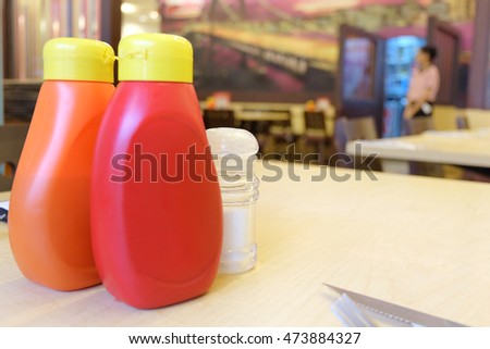 Plastic bottles with ketchup on the table in a cafe