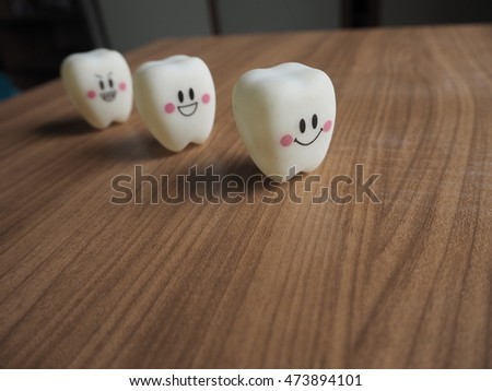 Emotion plastic tooth models in line on wooden background.