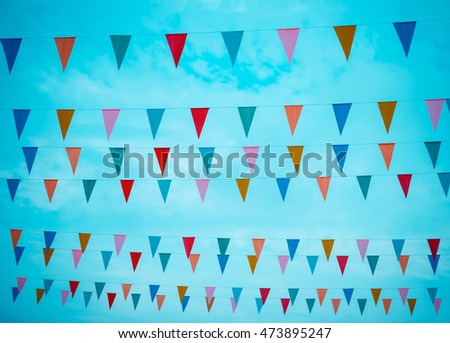 vintage tone image of festival flag line with blue sky in background on day time .
