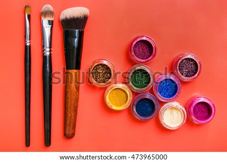 Various makeup products on red background 