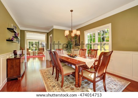 Brown and olive tones dining room interior. Large wooden table for six person. Northwest, USA