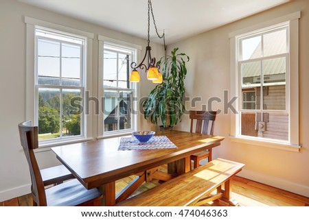 Close-up of wooden dining table with two chairs and bench. House interior. Northwest, USA