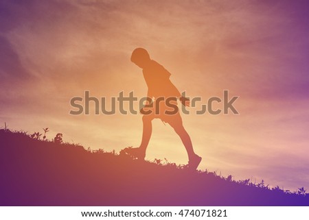 Silhouette a boy walking on sunset