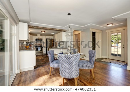 Dining area with blue chairs and table setting. And view of kitchen room. Northwest, USA