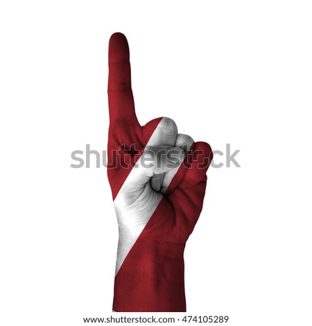 Hand pointing thumb up direction, latvia painted with flag as symbol of up direction, first and number one symbol - isolated on white background