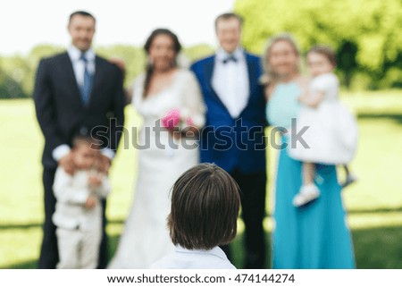 Little boy looks at the people posing for family picture